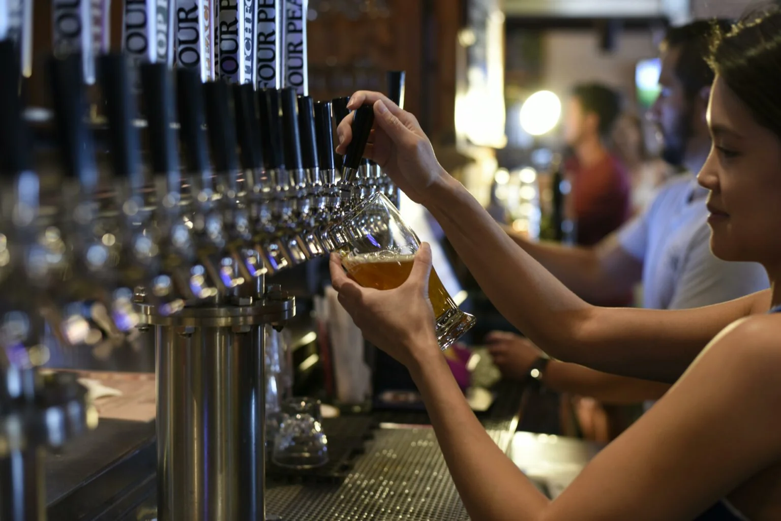 Bartender pouring a draught beer at a bar
